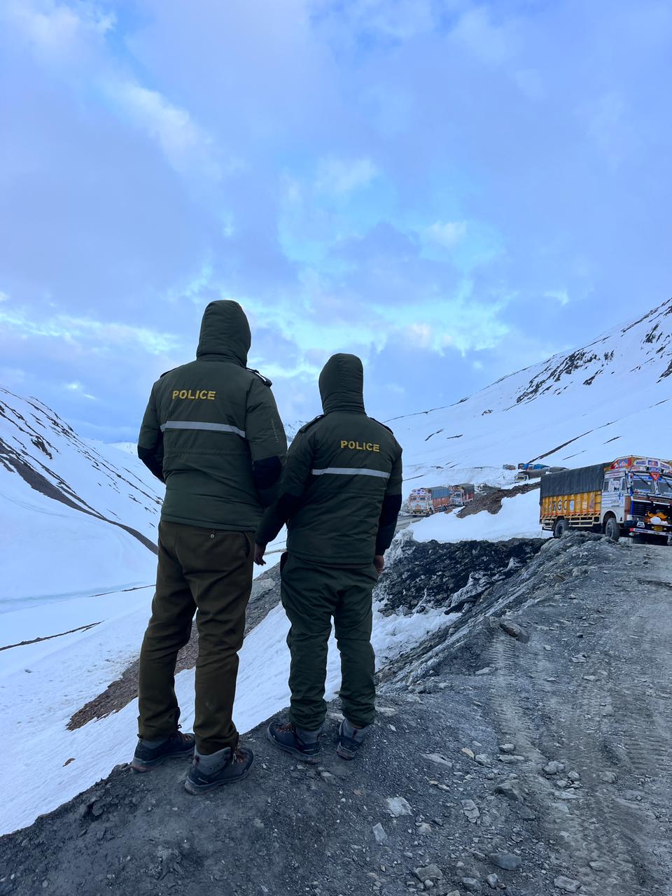 Cops keep an eye as heavy vehicles traverse mighty Baralacha pass on Manali Leh highway on Sunday - 19 May 2024